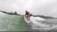        a man surfs the wake on lake arenal
  - Costa Rica