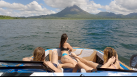        friends admiring the view of arenal volcano from the boat
  - Costa Rica