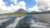        a couple of friends tubing on lake arenal with the view of the volcano
  - Costa Rica