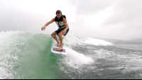        a man wakesufing on lake arenal in a rainy morning
  - Costa Rica