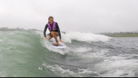        a smiling lady wakesurfs on lake arenal trying to keep balance
  - Costa Rica