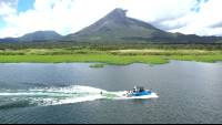        a wakesurfer follows the wake with a view of arenal volcano
  - Costa Rica
